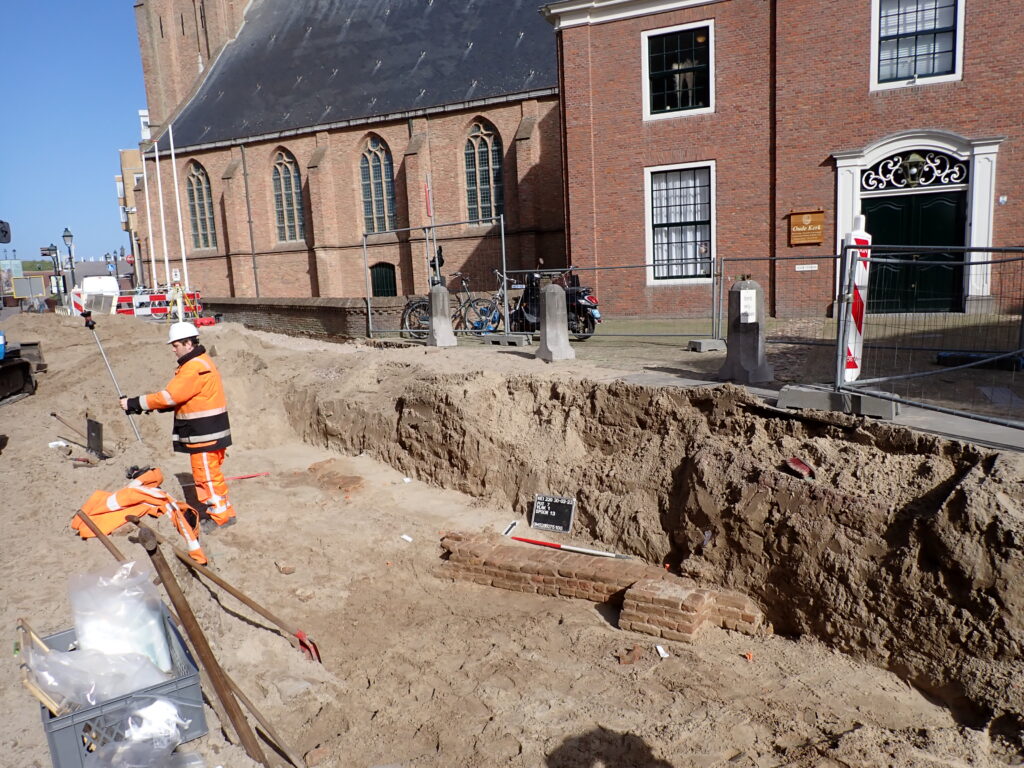 Foto 1: Tegenover de ingang van de Pastorie van de Oude Kerk is de fundering van een oude muur zichtbaar. Vermoedelijk gaat het om de oude zuidelijke grens van het kerkhof (foto: Archeologie Den Haag).